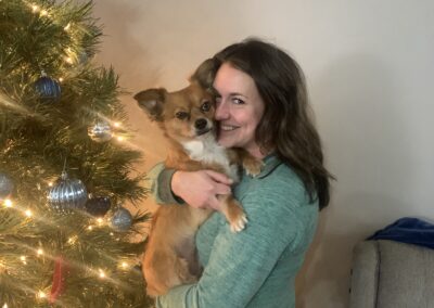 Kristina Bumgardner, nurse recruiter at Uniti Med standing in front of a holiday tree with her dog.