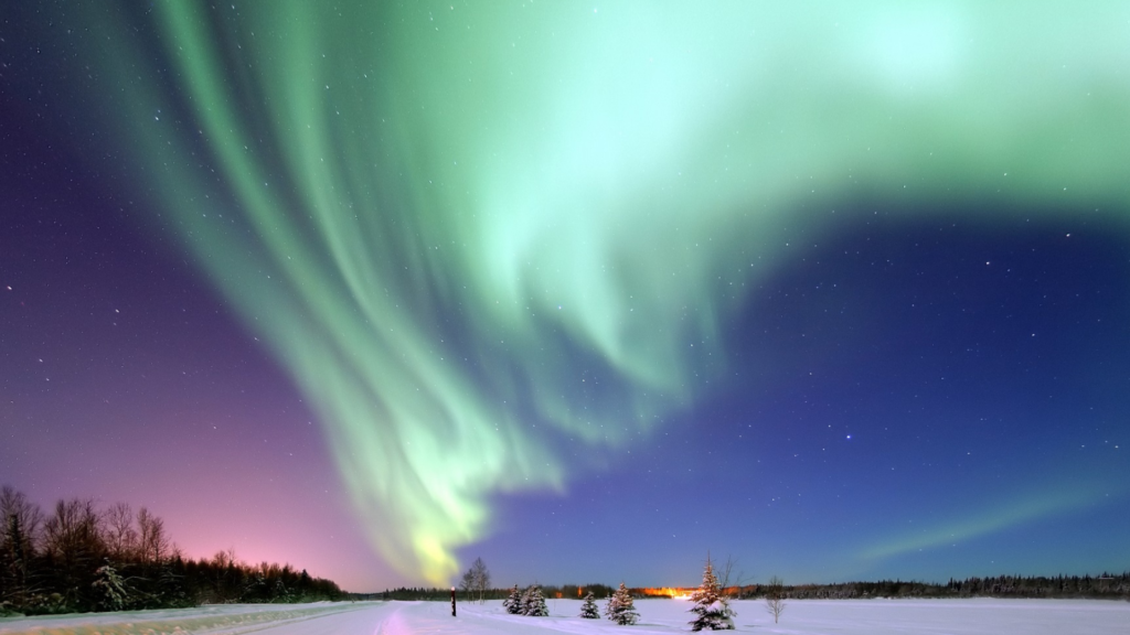 Northern lights dancing over a snow-covered Alaskan landscape