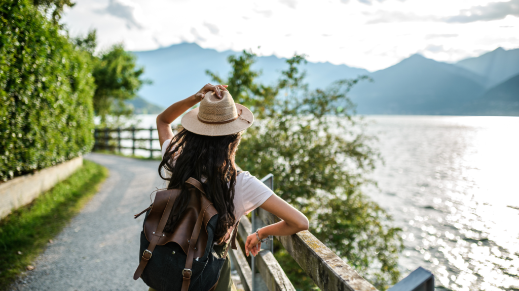 A person with a backpack set against a background showing mountains.