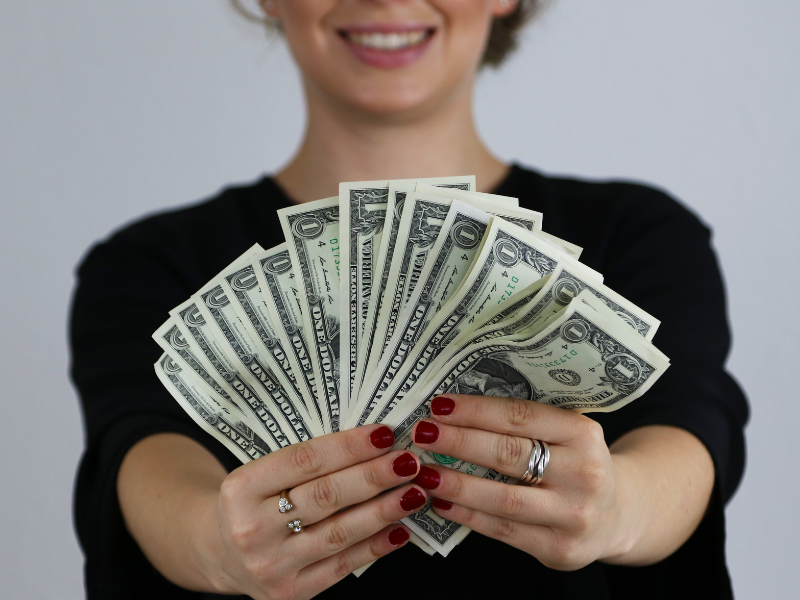 Travel nurse holding extra money