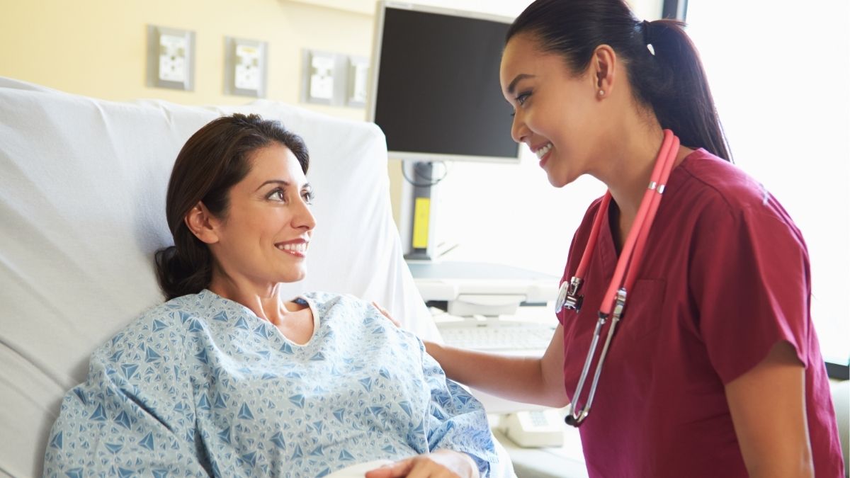 Nurse helping a patient in hospital bed